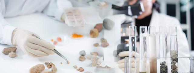 Concept of geologist or archaeologist is analyzing a sample of rock or mineral in paleontology,...