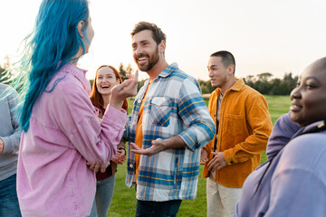 Group of stylish friends wearing colorful clothes, meeting, talking, outdoors, team building
