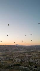 Hot air balloons. Hot air balloons flying over Fairy chimneys in Cappadocia at sunrise. Aerial view. Turkey tourist attractions