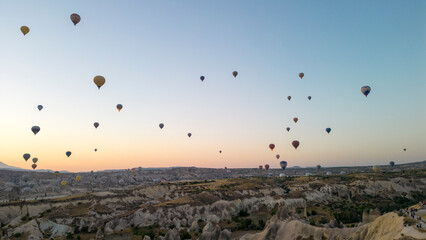 Hot air balloons. Hot air balloons flying over Fairy chimneys in Cappadocia at sunrise. Aerial view. Turkey tourist attractions