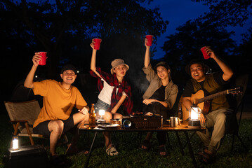 Happy asian diverse group friends enjoy drinking a beer together. They feeling relaxed and...