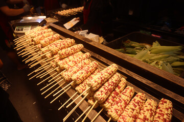 Corn on the Wooden Sticks on the Asian Night Market Counter