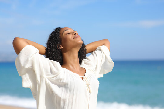 Black woman relaxing breathing on the beach