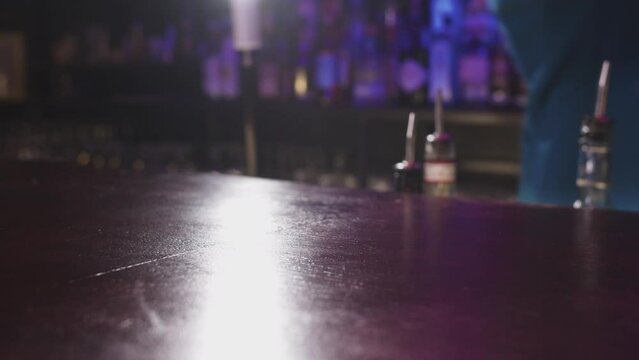 A Captivating Moment: Bartender's Cocktail Creation in Blurry Ambiance