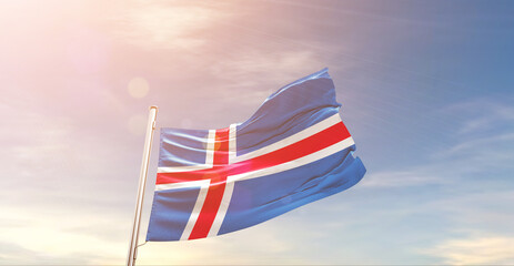 Iceland national flag waving in beautiful sky. The symbol of the state on wavy silk fabric.