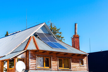 Private wooden house with blue shiny solar photovoltaic powered panels system.accumulate saving...