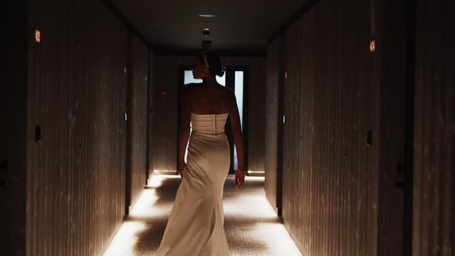 Stylish dark-skinned bride posing in a white dress at a wedding photo shoot. Wedding concept