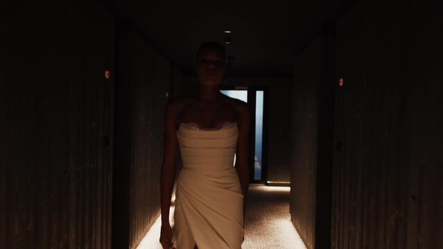 Stylish dark-skinned bride posing in a white dress at a wedding photo shoot. Wedding concept