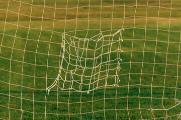 Old patched soccer goal net as abstract sport background