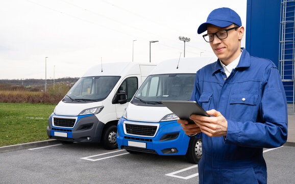 Manager with a digital tablet on the background of vans. Fleet management