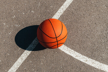 Basketball ball on outdoor court with asphalt surface