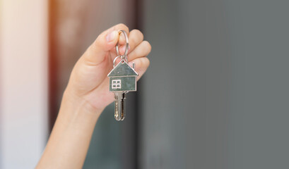 Moving house, relocation. Woman hold key house keychain in new apartment.