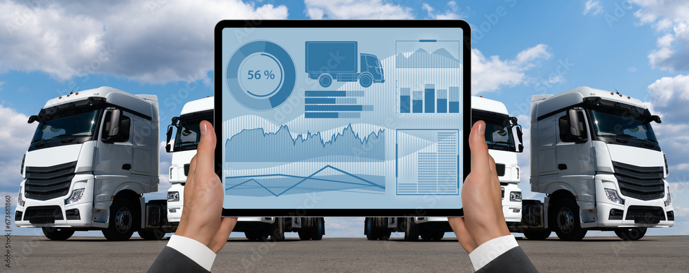 Poster manager with a digital tablet on the background of trucks. fleet management