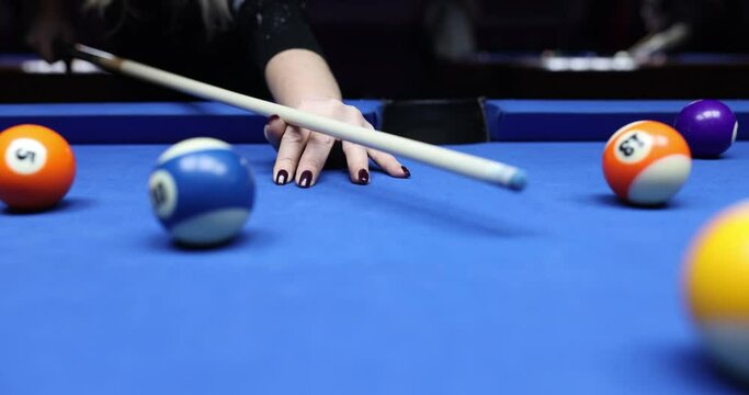 Female player shots ball to push goal into pocket on billiard table. Entertainment and game. Casino and nightlife concept slow motion