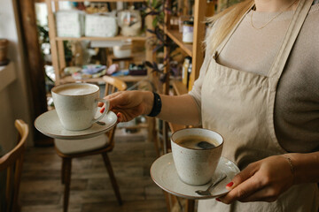 Waiter wearing apron serving coffee in cafe