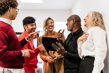 Happy multiracial businessmen and businesswomen enjoying work in office