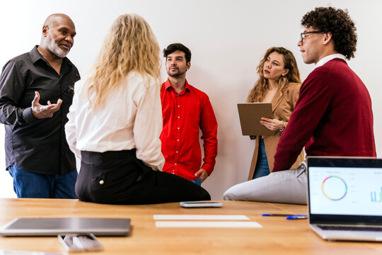 Mature businessman planning strategy with multiracial colleagues in office