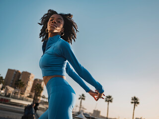 Beautiful woman in sports clothing posing with hands behind back