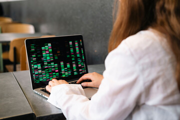 Young businesswoman coding on laptop at work place