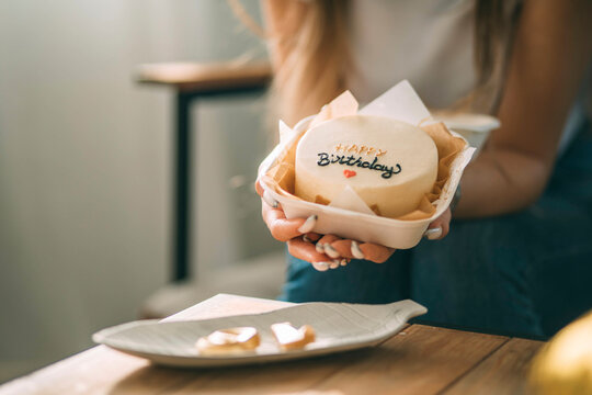 Young Woman Holding Birthday Cake In Hand At Home