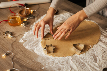 A close-up of the process of making New Year's gingerbread cookies in an atmospheric kitchen at home. Christmas mood. Recipe for New Year's treats