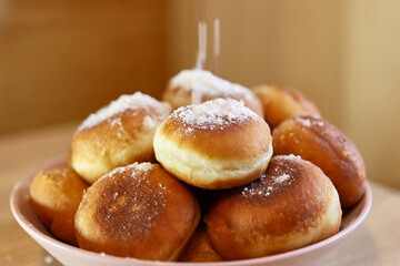 Fresh ruddy donuts with a sweet filling are sprinkled with powdered sugar.