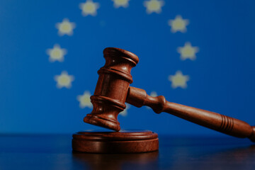 Flag of European Union and wooden judge gavel on a table. Law concept