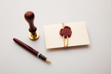 Envelope, wax stamp and pen on a table. Postal accessories
