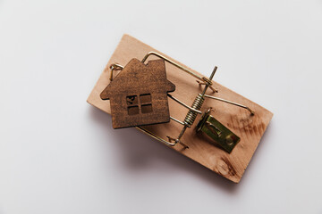 Mousetrap with wooden house. Fraud in real estate concept.
