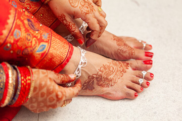 Indian Wedding Concept. An Indian bride wearing her silver Payal (anklets) on foot decorated with...