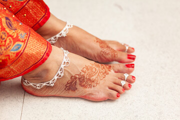 Indian Wedding Concept. Beautiful feet of an Indian bride, decorated with auspicious Mehndi,...