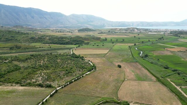 Farming land left untouched with mountains and the sea in the background
