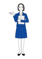 パソコンを持ってどうぞと右手を差し出して案内しているポーズのスーツ姿の女性