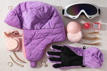 Warm winter clothes with accessories on a light background