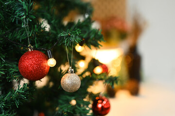 Christmas tree decorated with baubles with blurred shiny lights on background