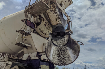 The concrete is unloaded from the concrete mixer, cement mixer truck is pouring fresh concrete on...