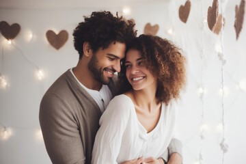 A beautiful young couple hugs and smiles in a bright room. - obrazy, fototapety, plakaty