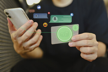 Young man holding credit card and using mobile phone making financial transaction or shopping online