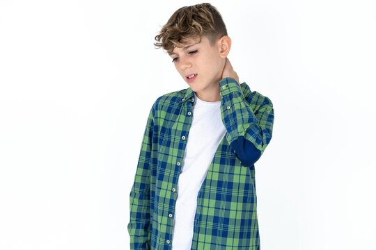 Caucasian teen boy Suffering of neck ache injury, touching neck with hand, muscular pain