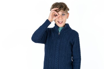 Caucasian teen boy doing ok gesture with hand smiling, eye looking through fingers with happy face.