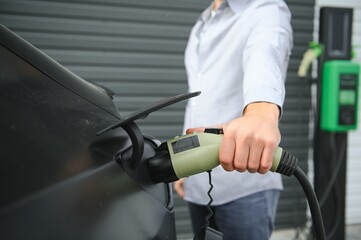 a man charges an electric car