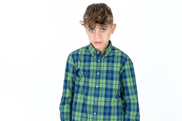 caucasian kid boy wearing plaid shirt depressed and worry for distress, crying angry and afraid. Sad expression.