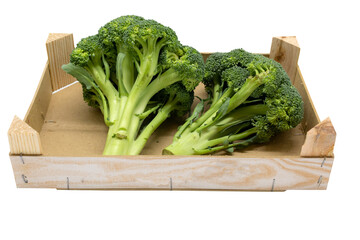Fresh broccoli in a wooden crate on a white background.
