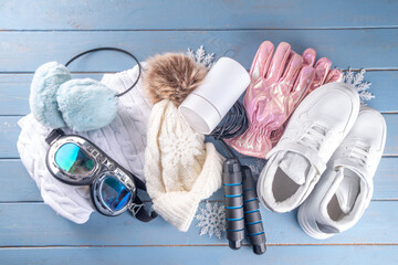 Winter sport and fitness, active lifestyle background. Warm knitted hat, sweater, jump rope, ski...