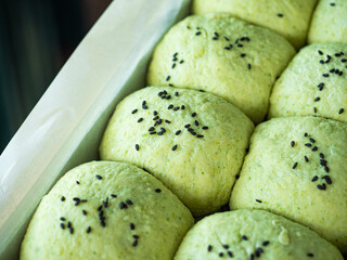green bread rolls with black sesame seed topping