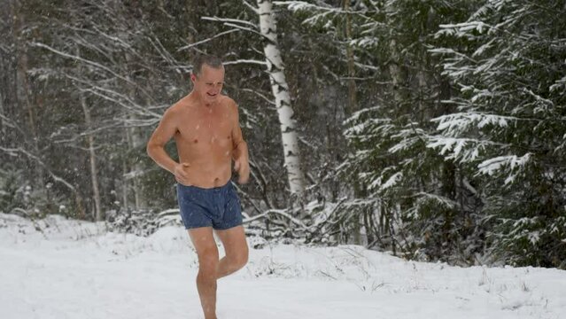 Naked elderly man jogging in the snow, 4k slow motion