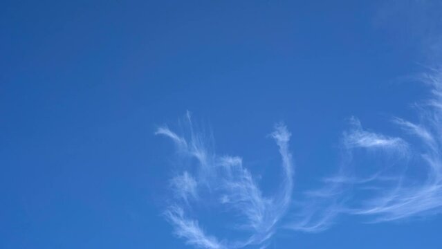 White whispy clouds rolling across a clear blue sky