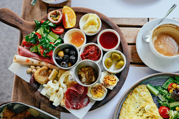 Turkish breakfast served on a wooden board in a restaurant, top view. Coffee, omelette 