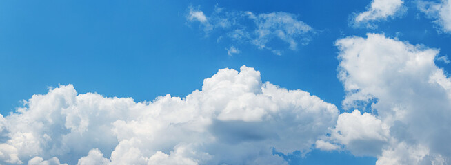 White curly clouds in the blue sky in sunny weather