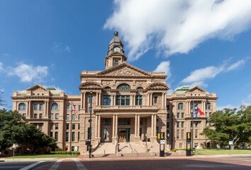 Tarrant County Courthouse in Fort Worth with the Texas flag fluttering in the wind.